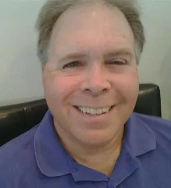 Portrait of Randy M. Sonns, smiling, in a blue polo shirt