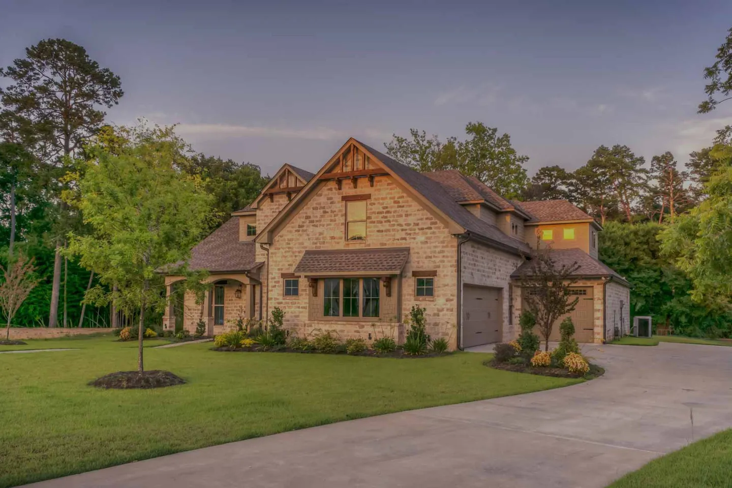Brick and stone single-family home with a landscaped lawn (illustrative)